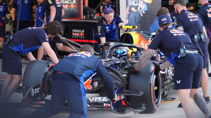 Isack Hadjar sits in his Red Bull as mechanics push it back into the team's garage.