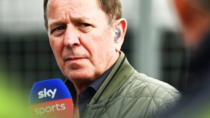 A close-up shot of Martin Brundle holding a Sky F1 microphone