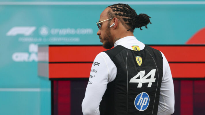 Lewis Hamilton has his back turned to the camera while looking to the left