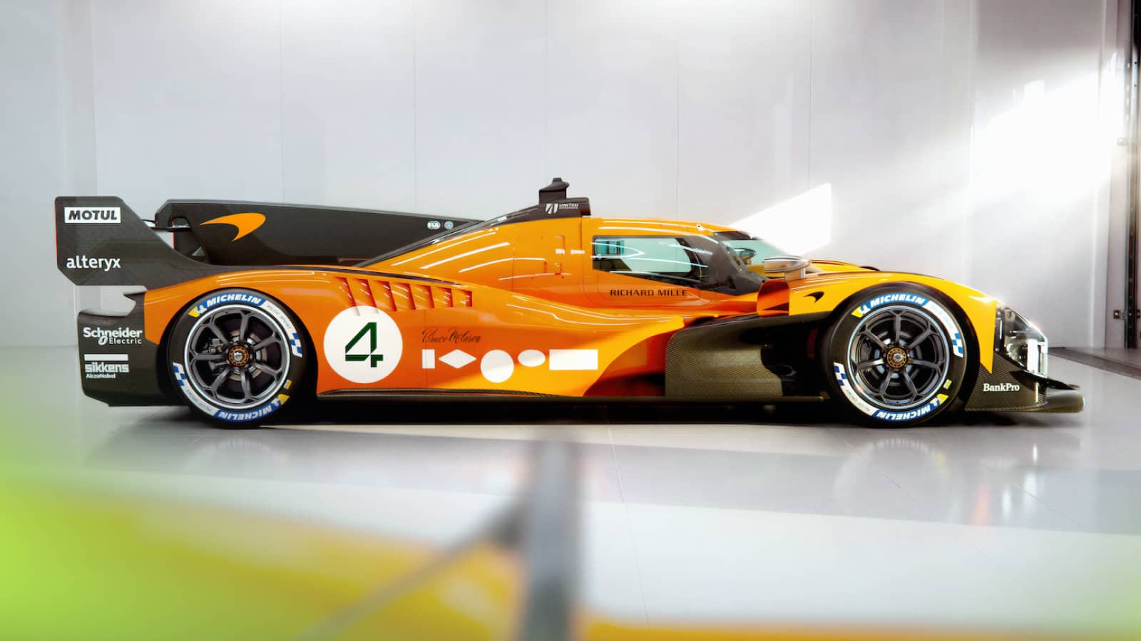 A side-profile shot of the McLaren MCL-HY hypercar in a garage setting