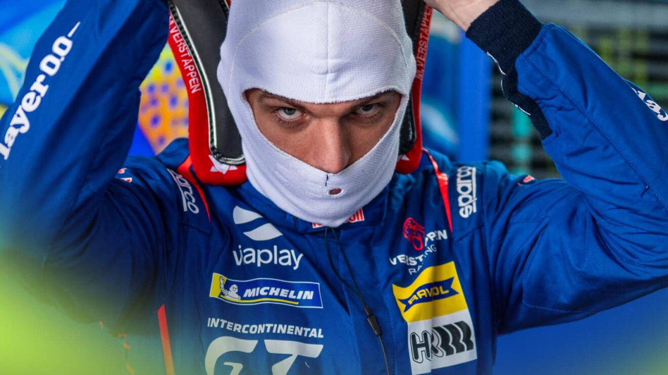 Max Verstappen's eyes and nose visible through his balaclava as he prepares to put on his helmet