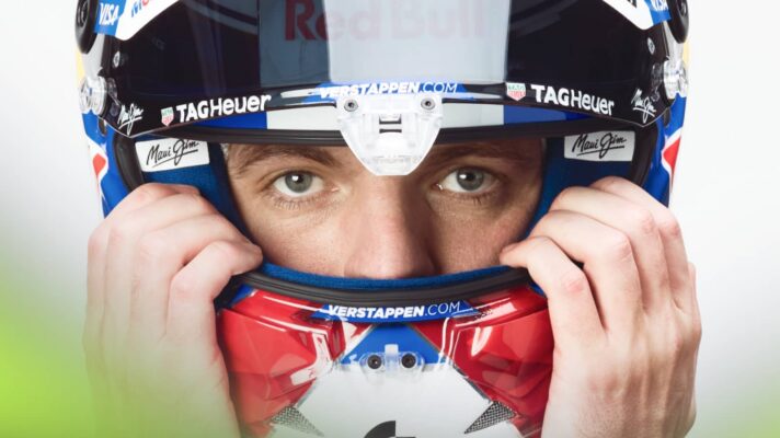 A close-up shot of Max Verstappen holding on to his helmet with his visor open