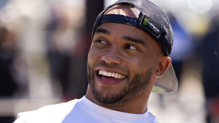 Nicolas Hamilton smiling in the paddock as he wears a cap on backwards