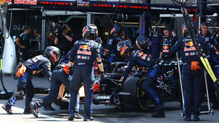 Max Verstappen pulls into the pits to retire his Red Bull RB22, car pushed into the garage by mechanics
