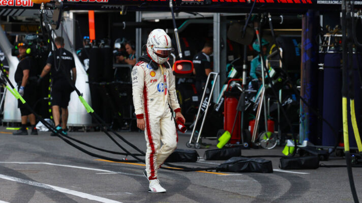 Charles Leclerc walks down pit late after crashing out of the Monaco Grand Prix, past the Red Bull garage