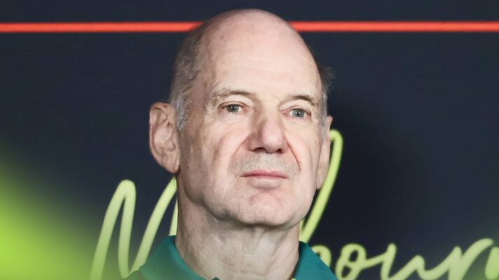 Adrian Newey looks in a press conference while wearing Aston Martin team kit
