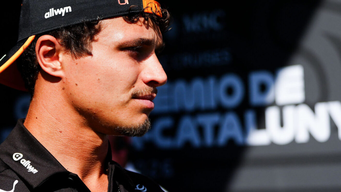 Lando Norris walking past the Circuit de Catalunya signage