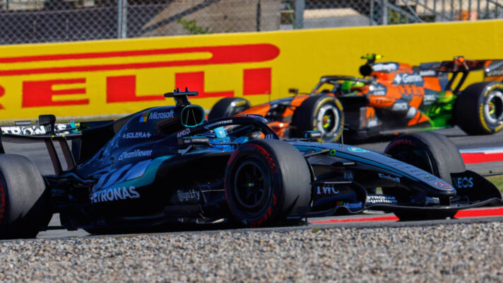 George Russell runs ahead of Lando Norris as they two round the corner