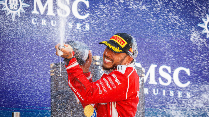 Lewis Hamilton with a huge smile sprays champagne his debut Ferrari win on the podium