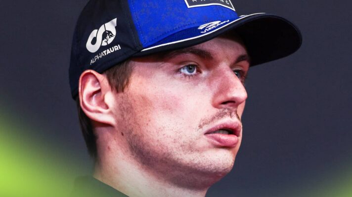 A close-up shot of Max Verstappen wearing a Red Bull cap