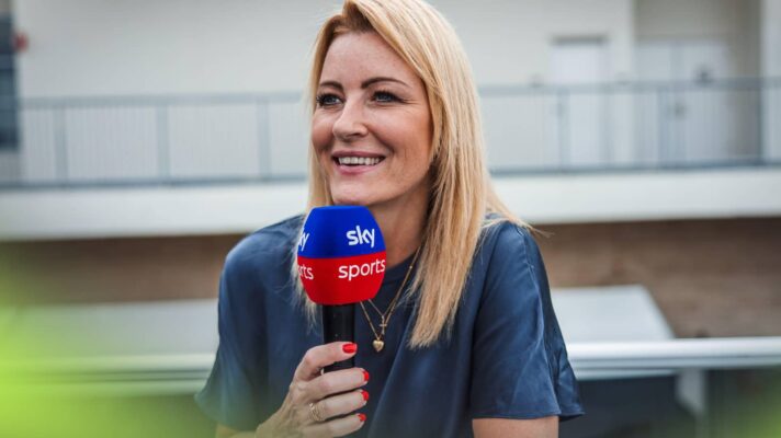 Rachel Brookes smiles as she poses while holding a Sky Sports microphone