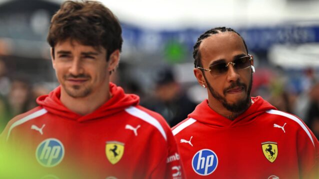 Charles Leclerc walking ahead of Lewis Hamilton in the paddock with both men wearing red Ferrari hoodies