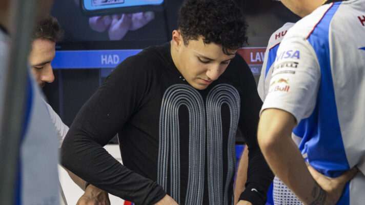 Isack Hadjar adjusts his cooling vest in the Racing Bulls garage in 2025
