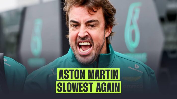 Fernando Alonso with his mouth open wide in the paddock with a banner reading: 'Aston Martin slowest again'
