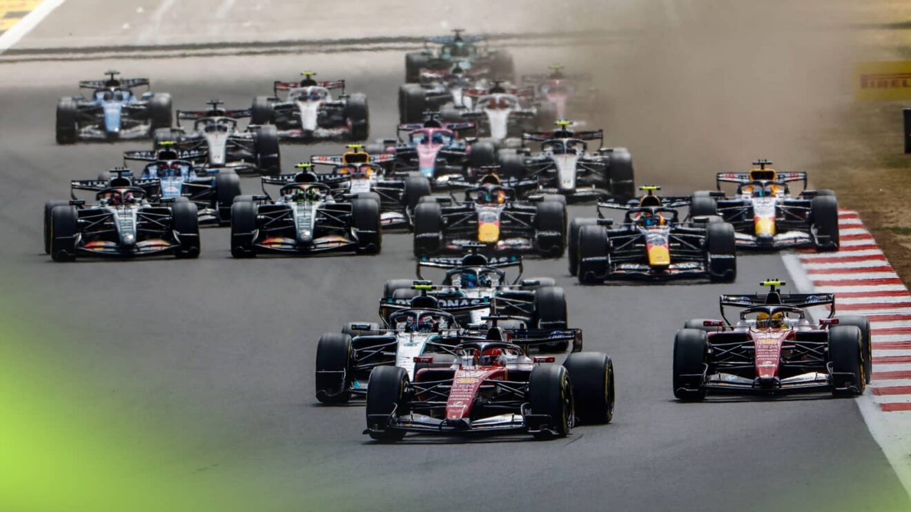 The F1 field approaches the first corner at the start at Silverstone