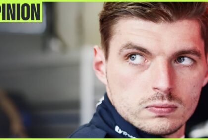 A close-up shot of Max Verstappen looking on in the Red Bull garage with an 'opinion' tab in the top-left corner