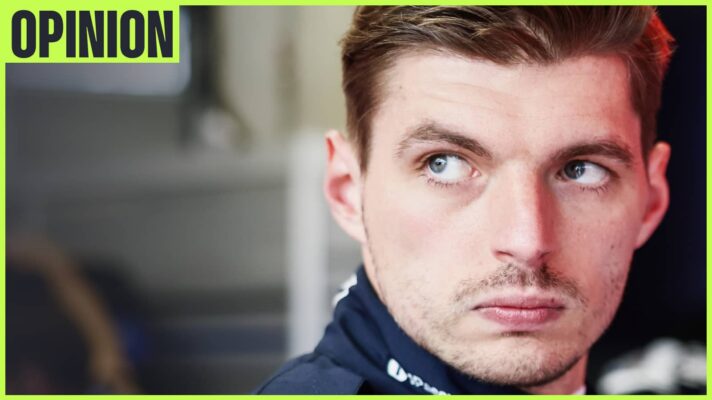 A close-up shot of Max Verstappen looking on in the Red Bull garage with an 'opinion' tab in the top-left corner