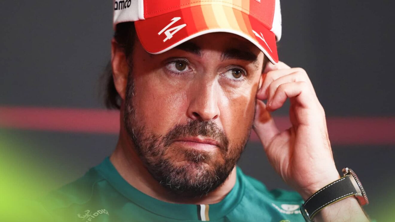 Fernando Alonso touches his face in a press conference