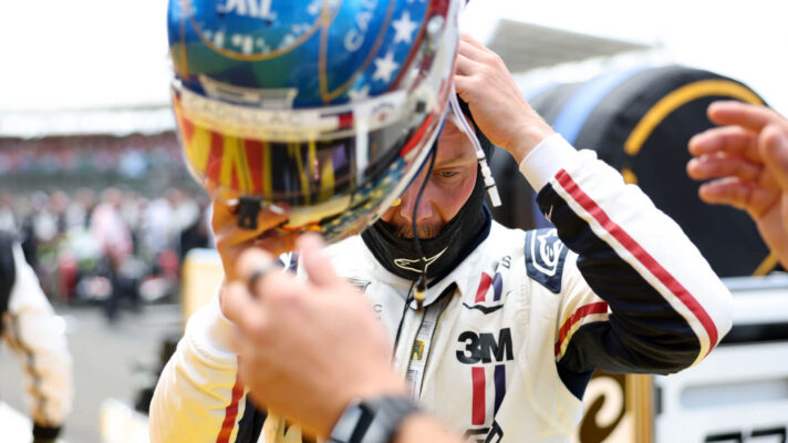 Valtteri Bottas puts on his helmet while standing on the grid