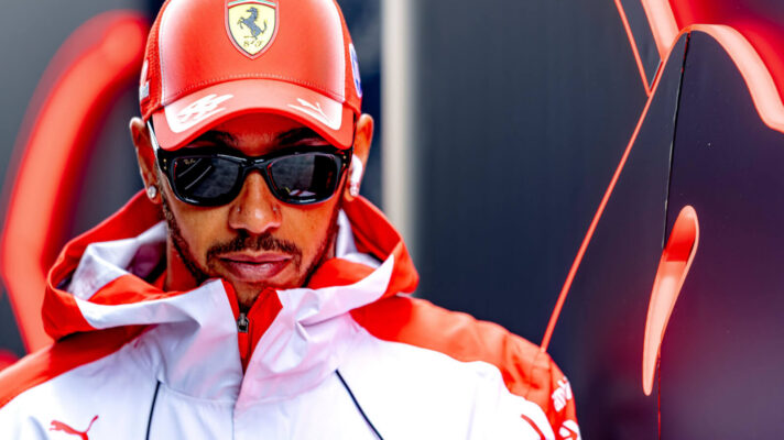 Lewis Hamilton, head down, Ferrari cap and sunglasses