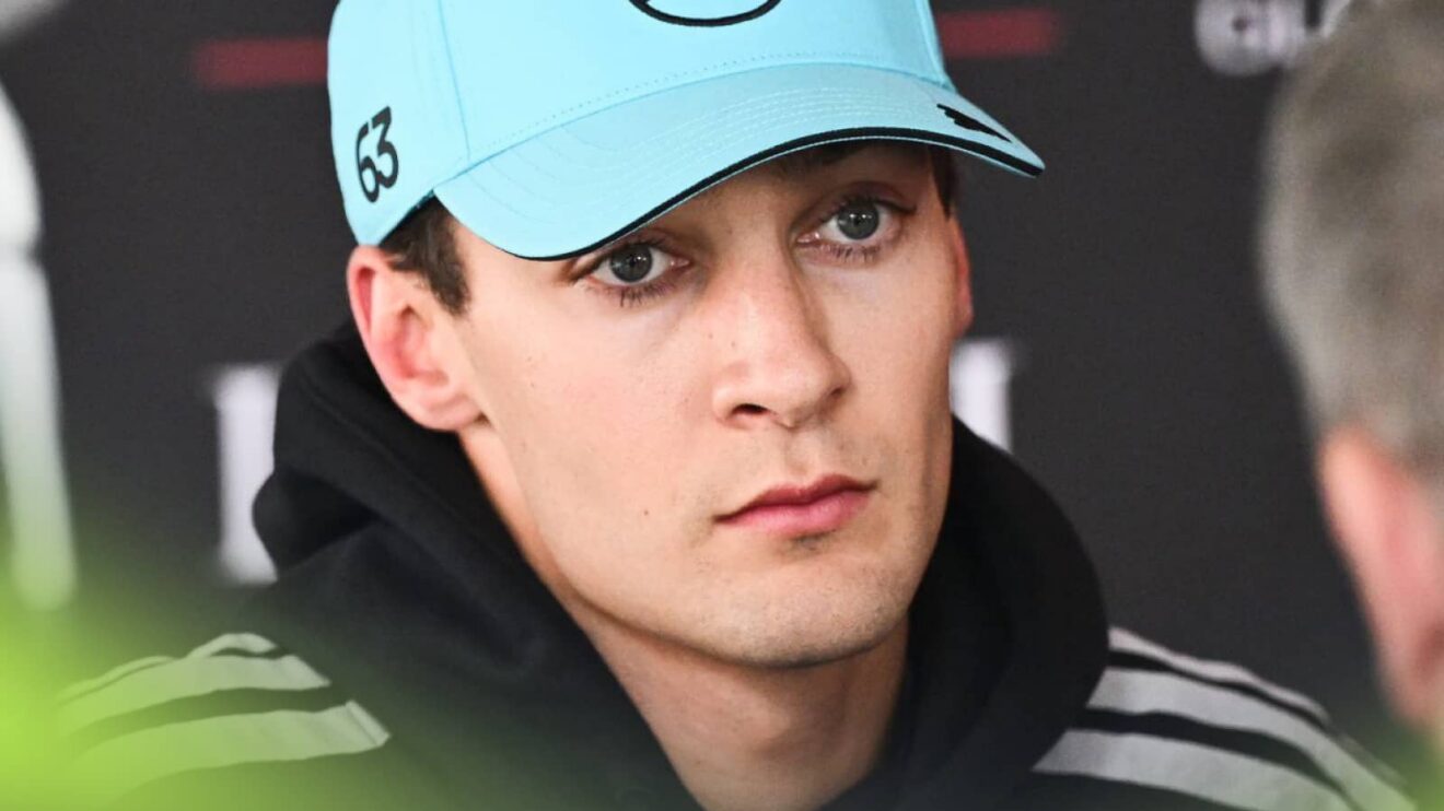 George Russell looks on as he faces questions from the media