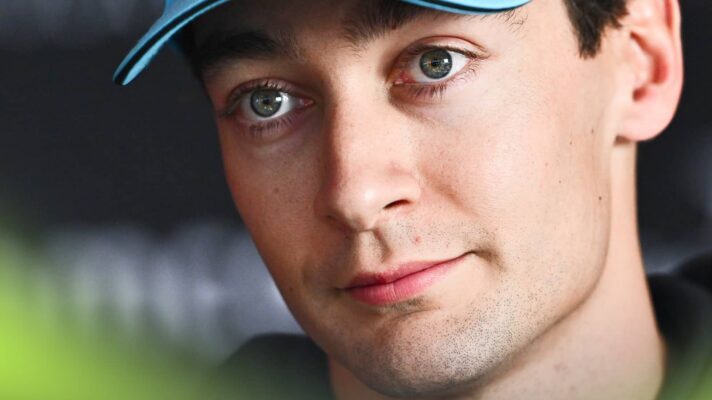 A close-up shot of George Russell facing the media