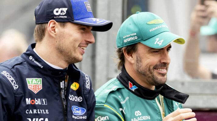 Max Verstappen and Fernando Alonso walking side-by-side, smiling