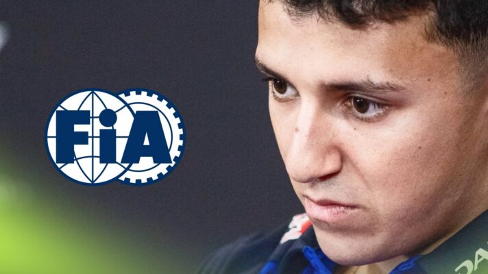 Isack Hadjar looks on in a press conference with an FIA logo alongside him
