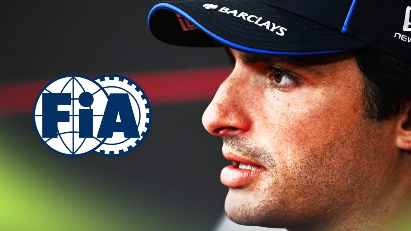 A side-profile shot of Carlos Sainz sitting in a press conference with a prominent FIA logo alongside him