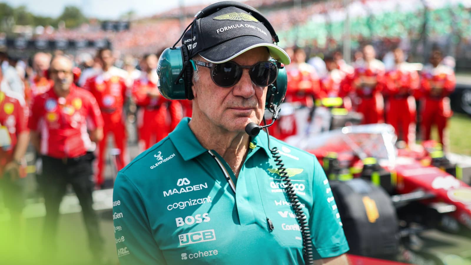 Adrian Newey observes the national anthem while standing next to Lewis Hamilton's Ferrari on the grid with Carlo Santi in the background