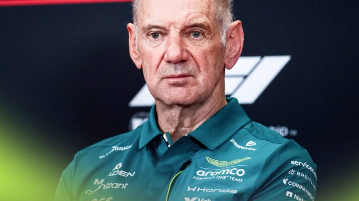 Adrian Newey looks on in a press conference while wearing green Aston Martin team kit