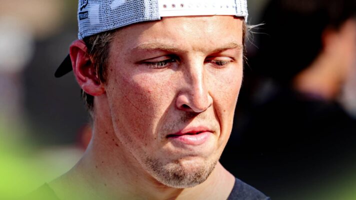 A close-up shot of Liam Lawson grimacing with his cap on back to front