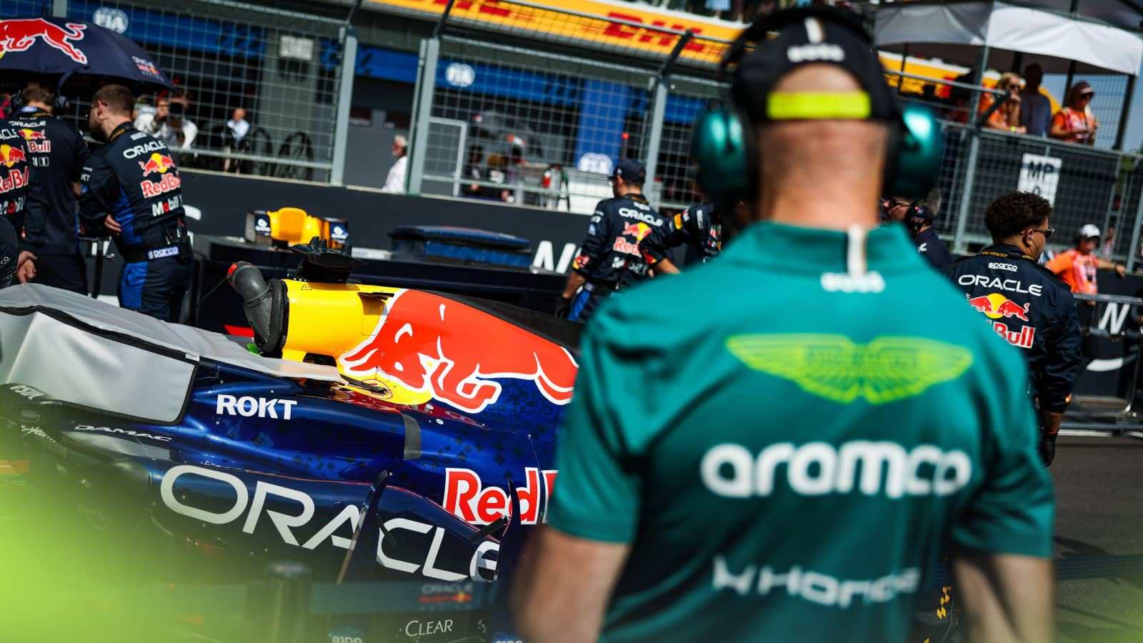 A rear-facing shot of Adrian Newey examining the Red Bull of Max Verstappen on the grid
