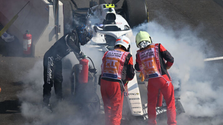 Valtteri Bottas joins marshals in putting out the fire from his Cadillac's brakes