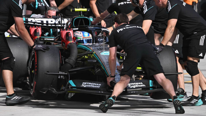Kimi Antonelli pulls into his Mercedes pit box, surrounded by mechanics