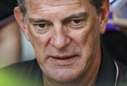 A close-up shot of Graeme Lowdon speaking to the media