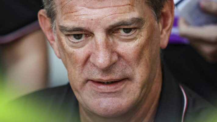 A close-up shot of Graeme Lowdon speaking to the media