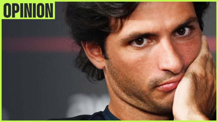 A close-up shot of Carlos Sainz holding his hand to his face with an 'opinion' tab in the top-left corner