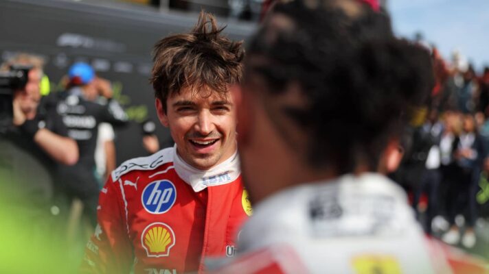 Charles Leclerc smiles in parc ferme at Silverstone with Lewis Hamilton in the foreground