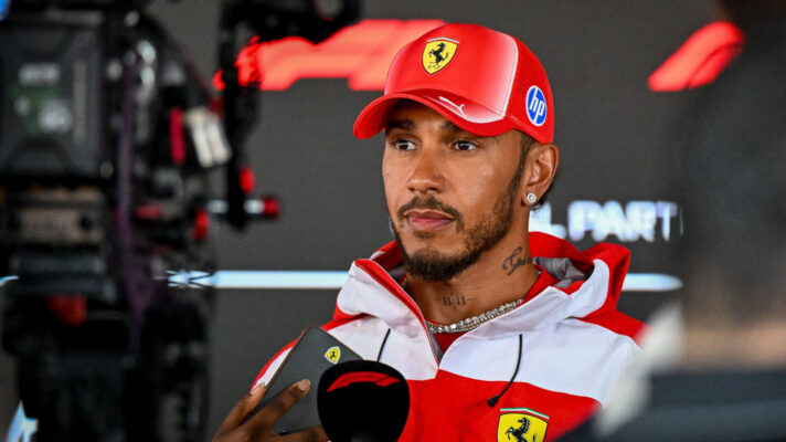 Lewis Hamilton in front of the camera as he is interviewed with an F1 mic in his hand