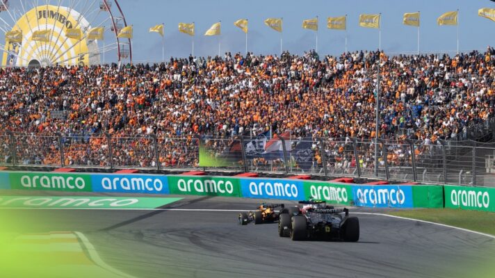 Cars head into Turn 3 at Zandvoort in front of packed grandstands.