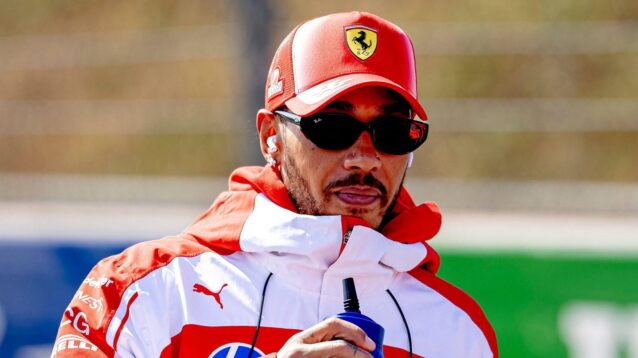 Ferrari driver Lewis Hamilton wearing sunglasses on a track walk at Zandvoort.