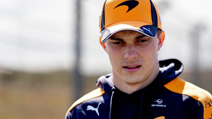 McLaren driver Oscar Piastri looks down at the floor.