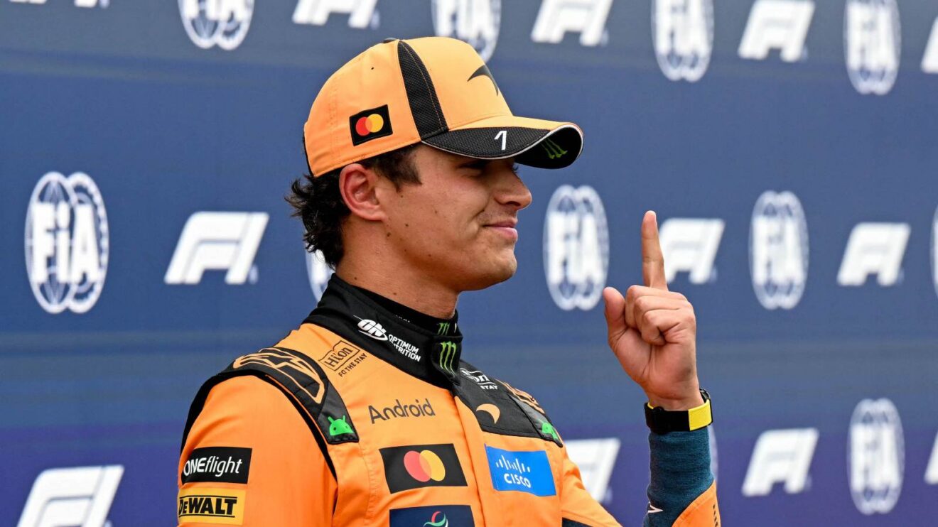 Lando Norris raises a finger after taking pole position.