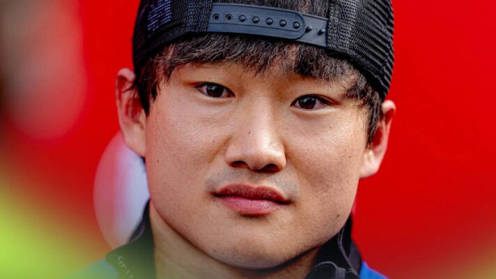 A close-up shot of Yuki Tsunoda against a red background