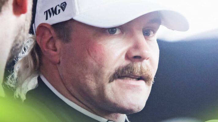 A close-up shot of Valtteri Bottas glancing to the side as he speaks to the media