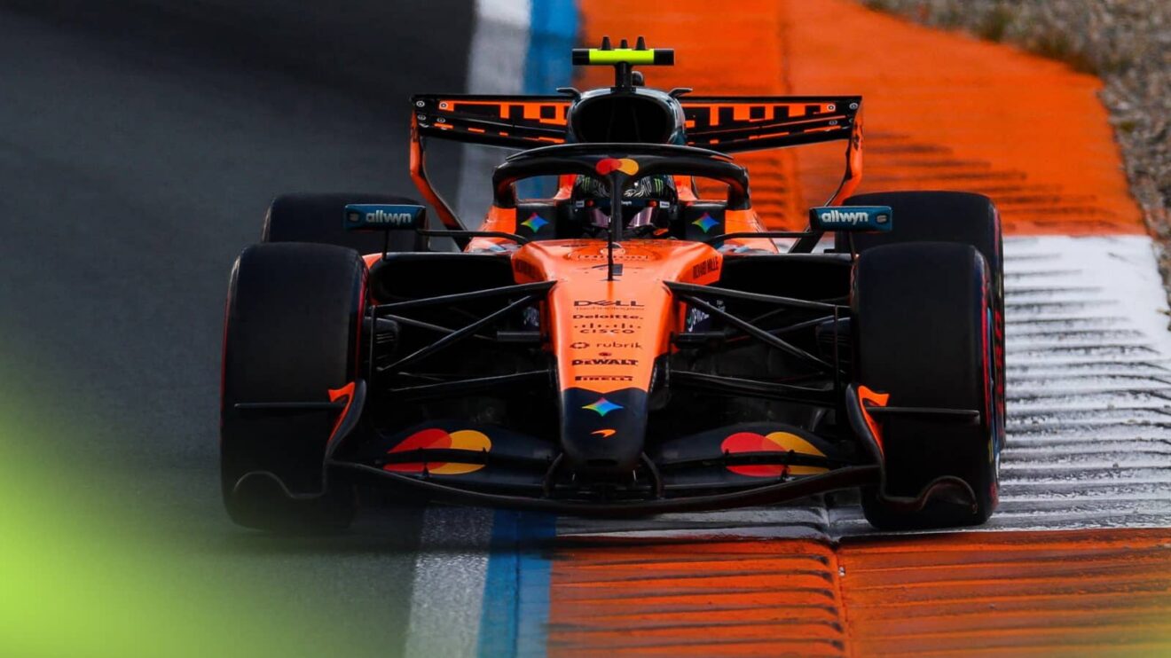 An action shot of Lando Norris's McLaren running over an orange-and-white kerb at Zandvoort