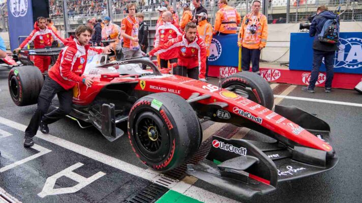 Ferrari mechanics move the SF-26 off the grid.