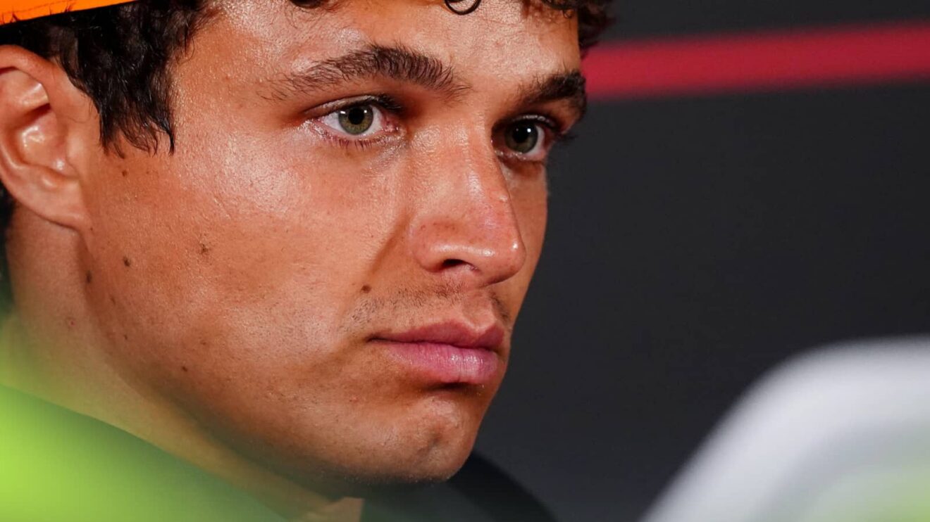 A close-up shot of Lando Norris looking on in a press conference