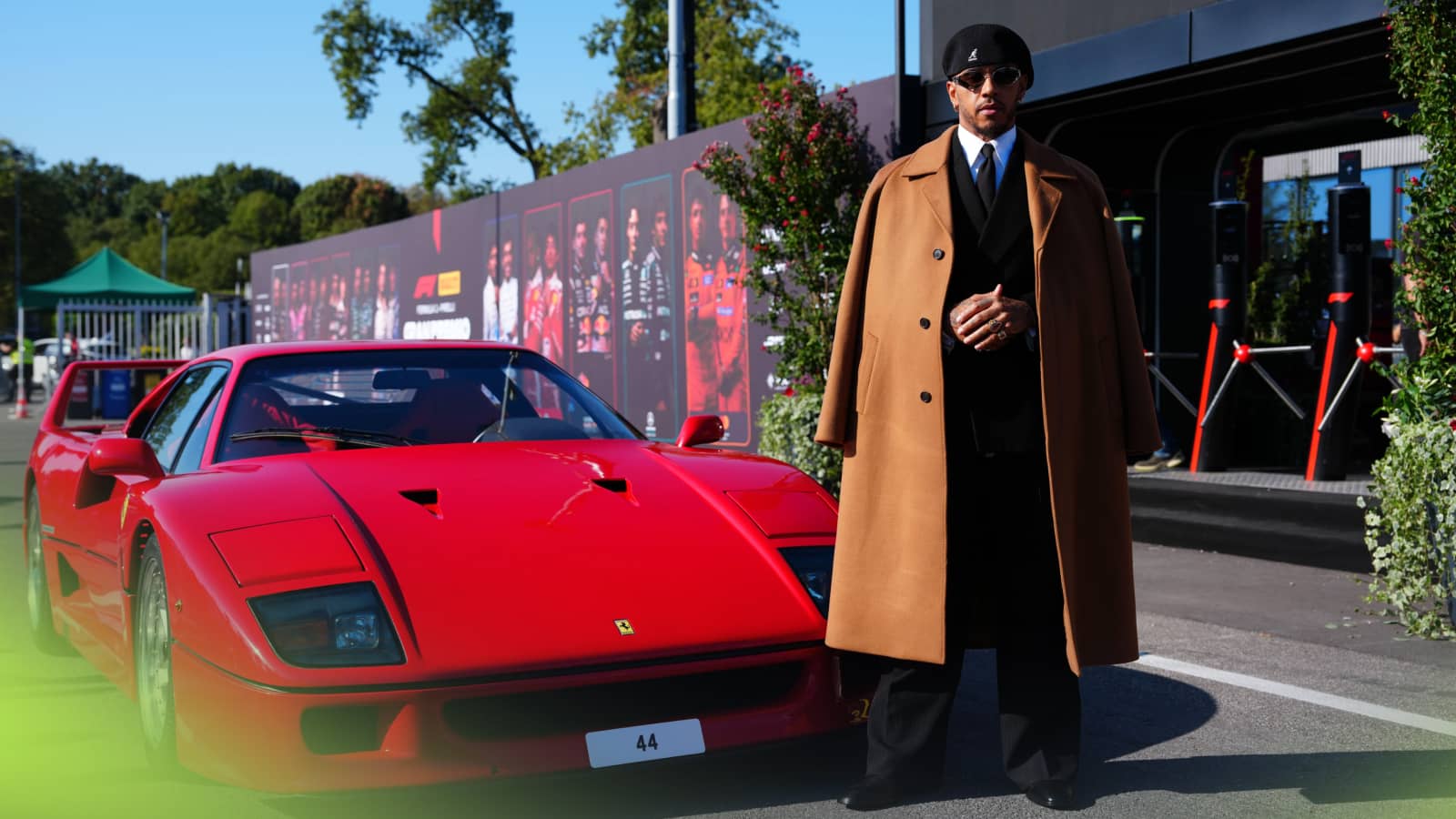 Lewis Hamilton poses in an overcoat and beret alongside a Ferrari F40 as he arrives at Monza